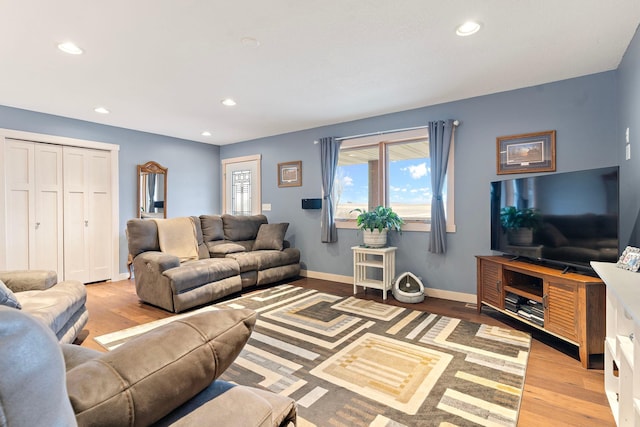 living room with recessed lighting, light wood-style flooring, and baseboards