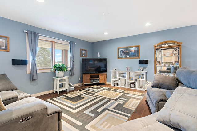 living area with baseboards, wood finished floors, and recessed lighting