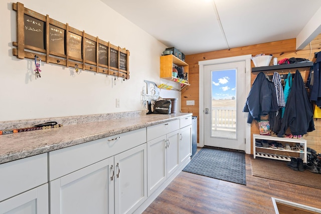 kitchen featuring open shelves, wood walls, wood finished floors, and white cabinets