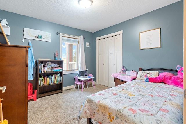 bedroom with carpet, a closet, a textured ceiling, and baseboards