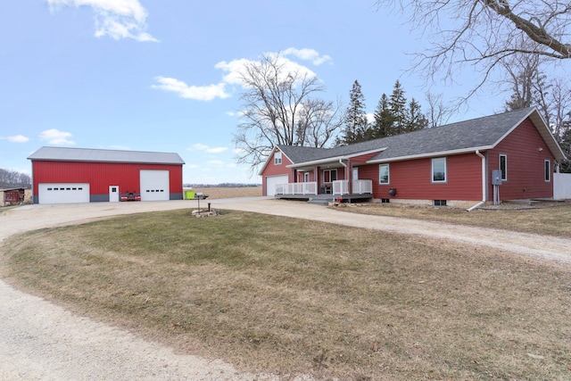 ranch-style house with a garage, a front yard, driveway, and an outbuilding