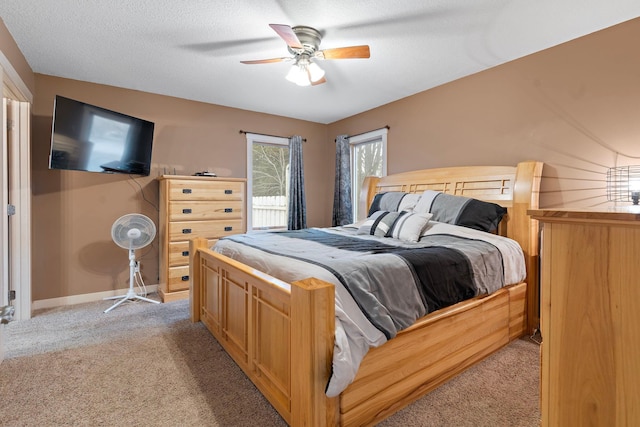 bedroom featuring ceiling fan, baseboards, light colored carpet, and a textured ceiling