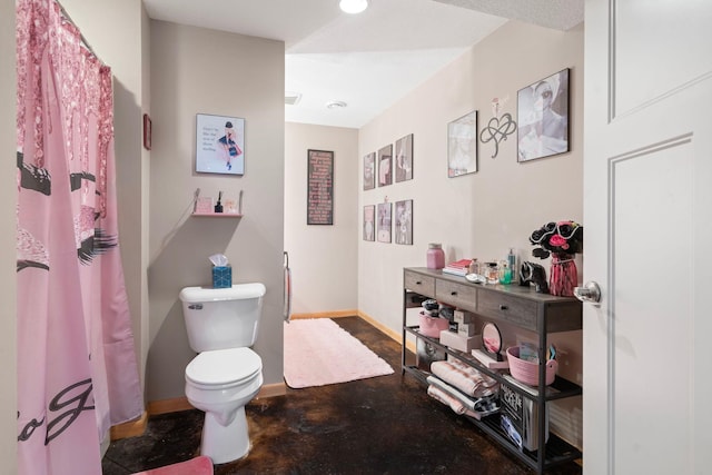 full bathroom featuring baseboards, a shower with shower curtain, toilet, and concrete flooring