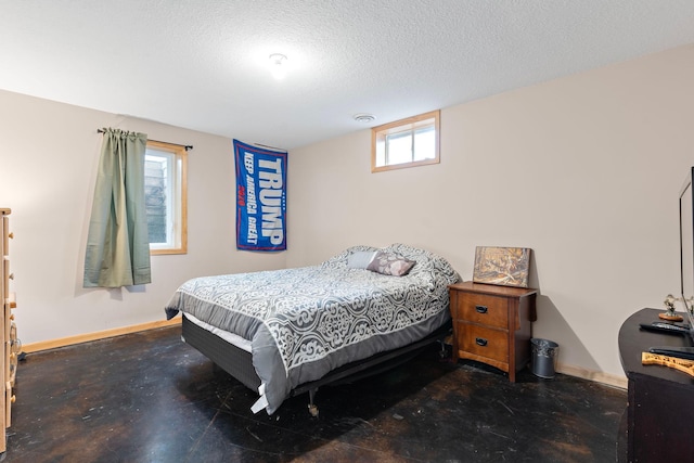 bedroom featuring concrete floors, baseboards, and a textured ceiling