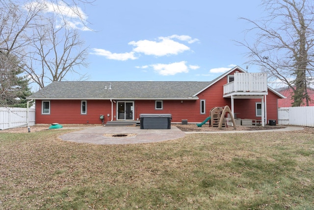 rear view of house featuring a fenced backyard, a lawn, a patio area, and a hot tub