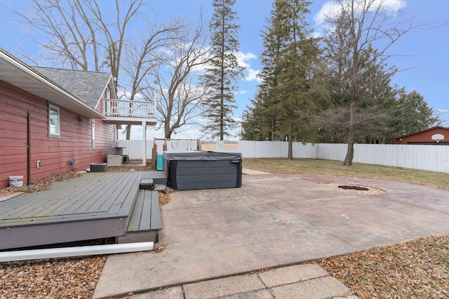 view of patio with an outdoor fire pit, a fenced backyard, a deck, and a hot tub