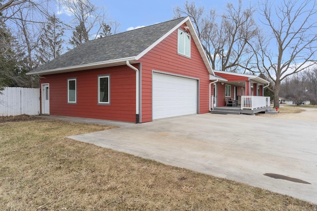 view of property exterior with concrete driveway, fence, a garage, a porch, and a yard