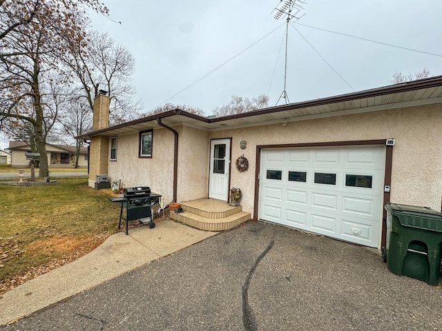 ranch-style home featuring a garage and a front lawn