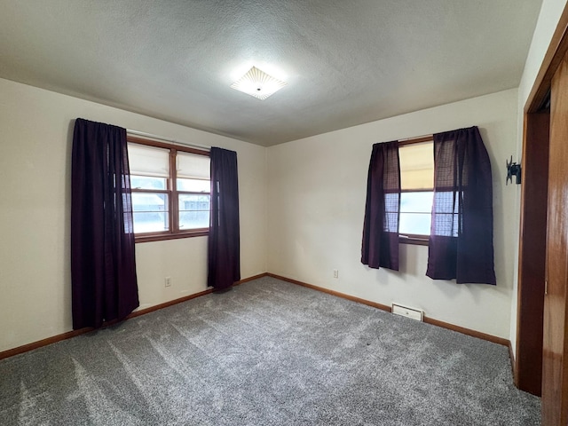 carpeted spare room featuring a textured ceiling