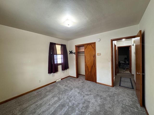 unfurnished bedroom with a closet, carpet, and a textured ceiling