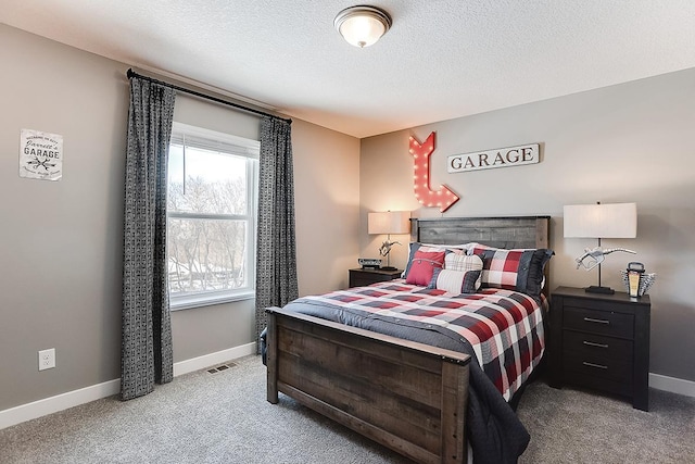 carpeted bedroom featuring a textured ceiling, visible vents, and baseboards