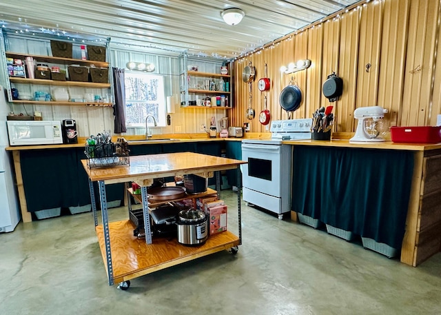 kitchen with open shelves, finished concrete floors, a sink, and white appliances