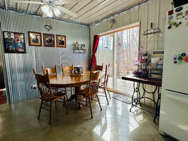 dining area featuring finished concrete flooring and a ceiling fan
