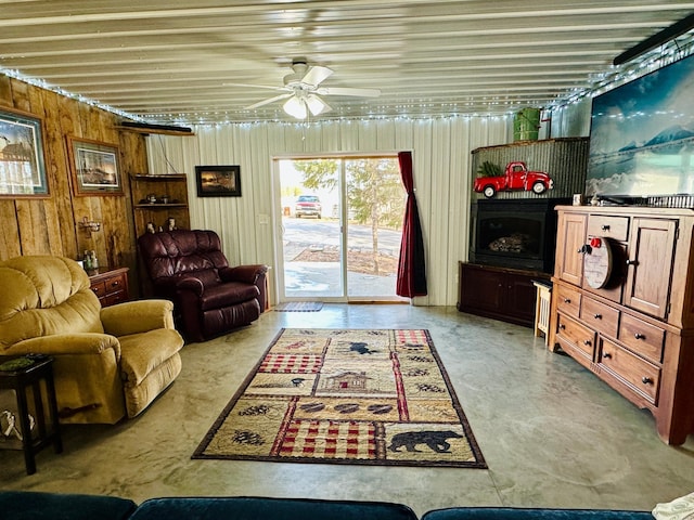 living area with wood walls and ceiling fan