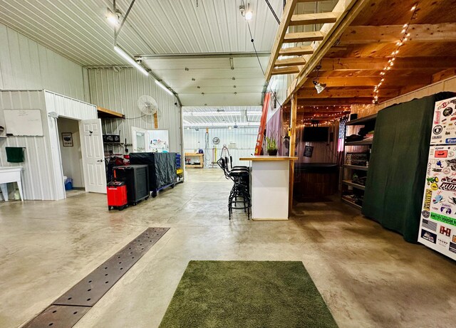 interior space with concrete flooring, metal wall, and a garage