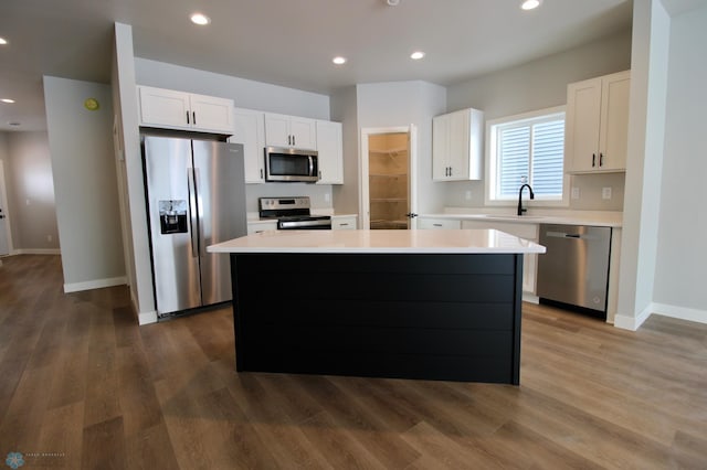 kitchen with white cabinetry, appliances with stainless steel finishes, a center island, and sink