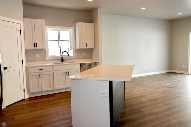 kitchen featuring sink, white cabinetry, a center island, dark hardwood / wood-style floors, and dishwasher