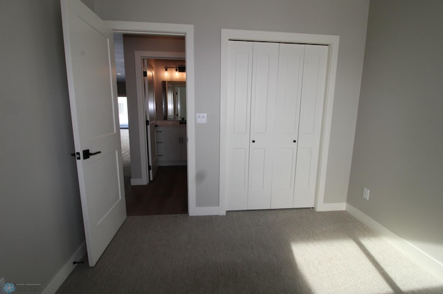 unfurnished bedroom featuring dark carpet and a closet