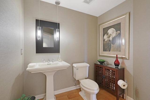 bathroom with wood-type flooring and toilet