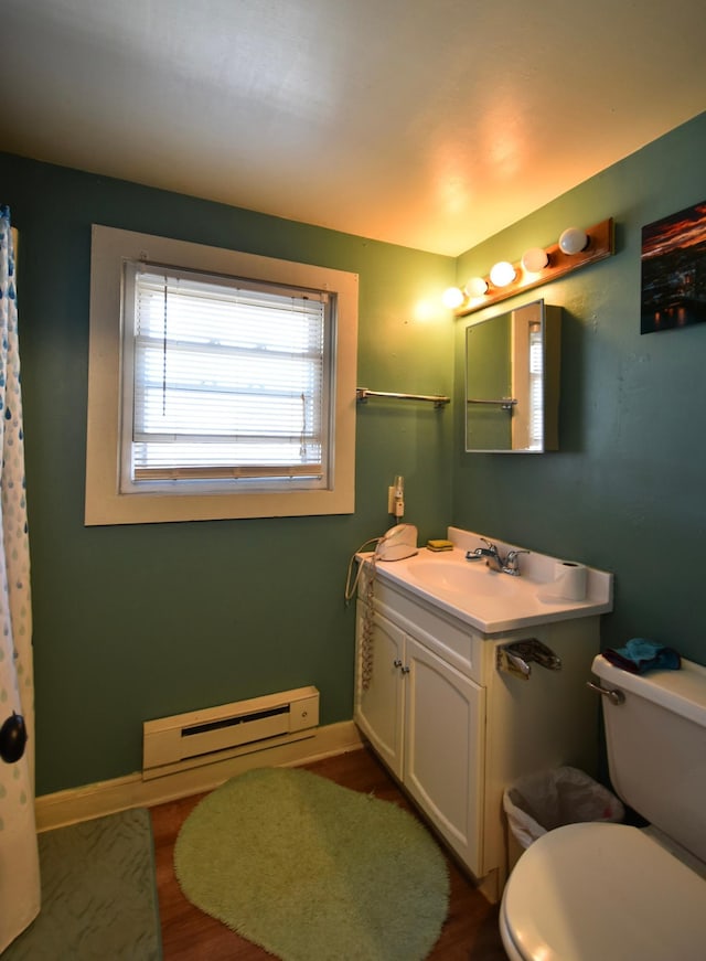 bathroom featuring vanity, hardwood / wood-style flooring, toilet, and a baseboard heating unit