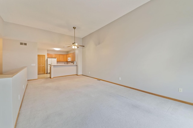 unfurnished living room featuring ceiling fan and light colored carpet