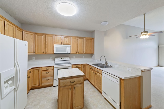 kitchen featuring white appliances, sink, a textured ceiling, a kitchen island, and kitchen peninsula