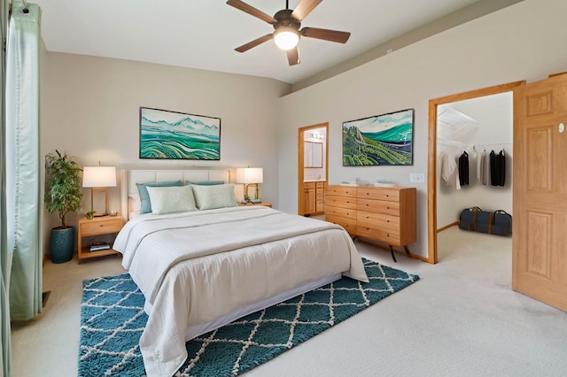 carpeted bedroom featuring a walk in closet, a closet, and ceiling fan