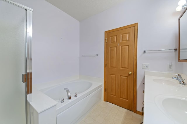 bathroom with vanity, shower with separate bathtub, and a textured ceiling