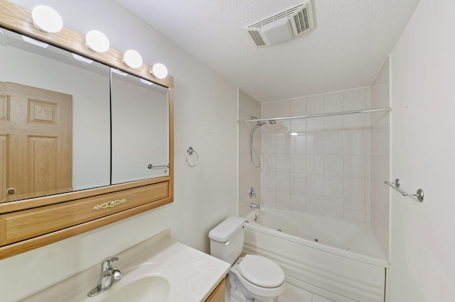 full bathroom with vanity, tiled shower / bath combo, a textured ceiling, and toilet