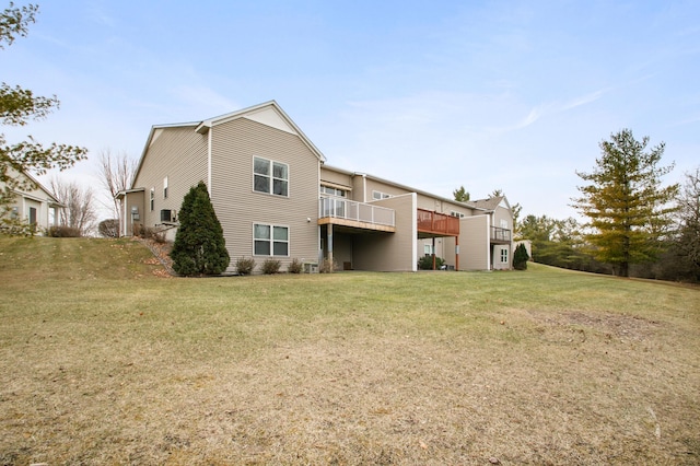 back of house with a balcony and a lawn