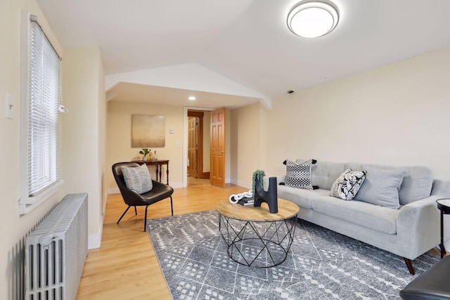 living room featuring radiator heating unit, hardwood / wood-style flooring, and lofted ceiling