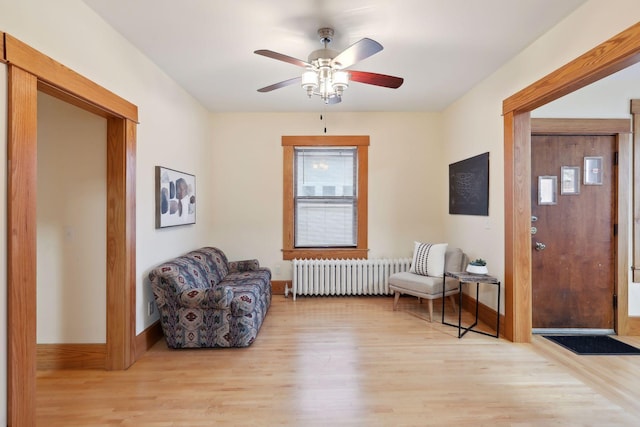 sitting room featuring radiator, ceiling fan, and light wood-type flooring