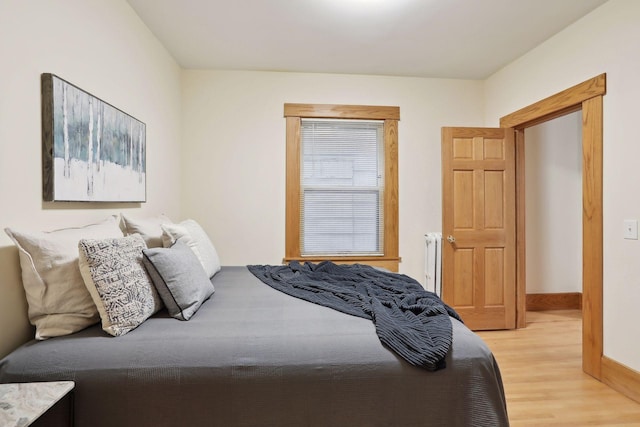 bedroom with radiator and light wood-type flooring