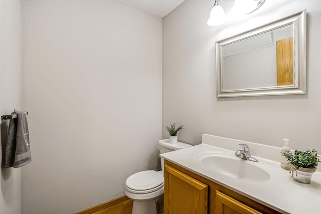 bathroom featuring hardwood / wood-style floors, vanity, a textured ceiling, and toilet