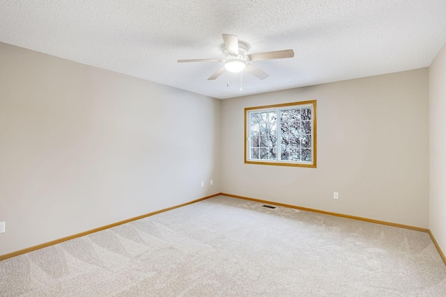 empty room with a textured ceiling, carpet floors, and ceiling fan