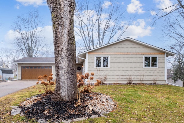 view of property exterior with a garage and a lawn