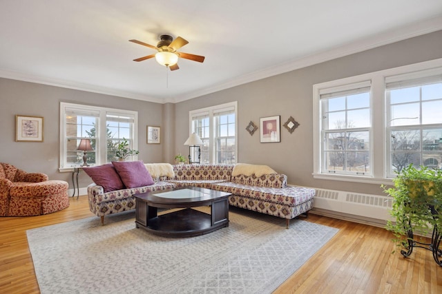 living room with hardwood / wood-style flooring, ornamental molding, and ceiling fan