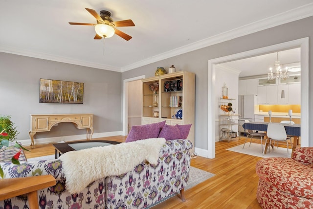 living room with ornamental molding, ceiling fan with notable chandelier, and light hardwood / wood-style flooring