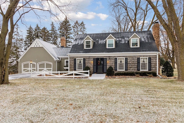 cape cod home featuring a garage and a front lawn