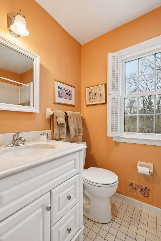 bathroom with toilet, tile patterned flooring, and vanity