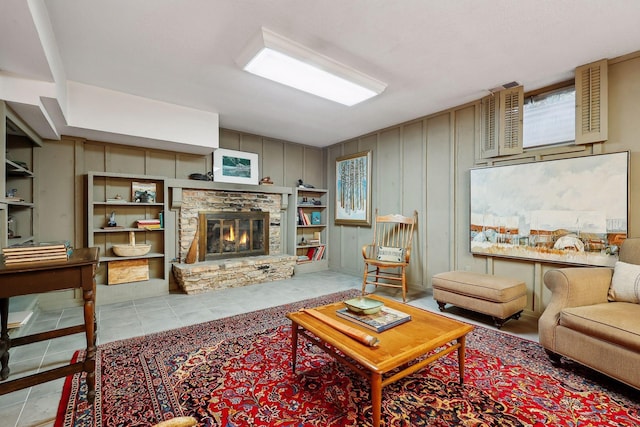 living room featuring light tile patterned flooring and a stone fireplace