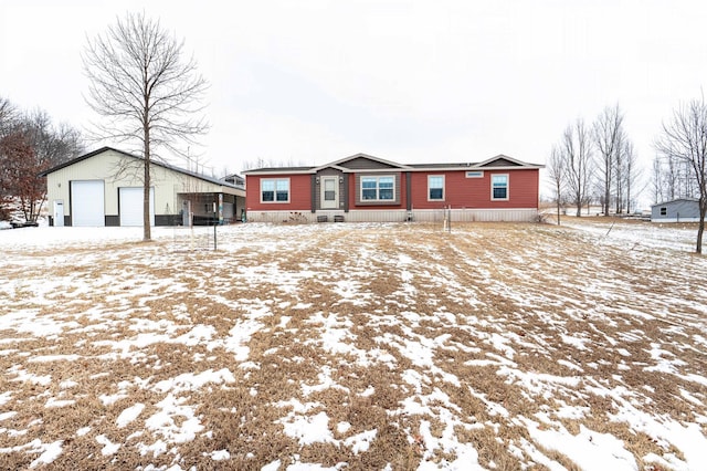 snow covered rear of property featuring a garage