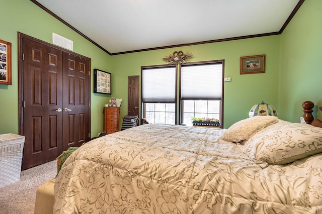 bedroom featuring carpet flooring, vaulted ceiling, crown molding, and a closet