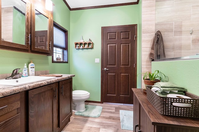 bathroom featuring hardwood / wood-style floors, vanity, toilet, and crown molding