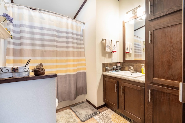 bathroom with a shower with curtain, vanity, tasteful backsplash, and toilet