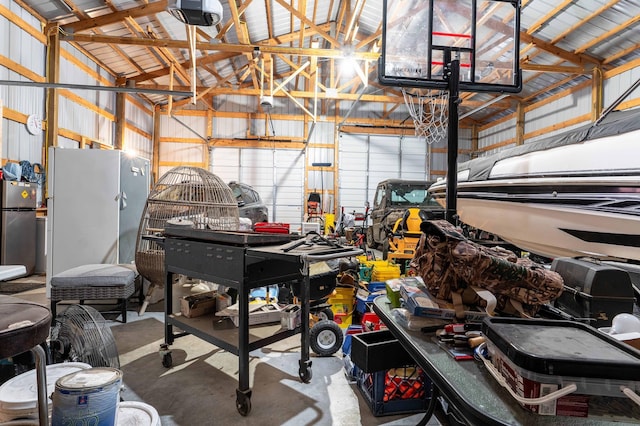 garage featuring stainless steel fridge, white fridge, and a garage door opener