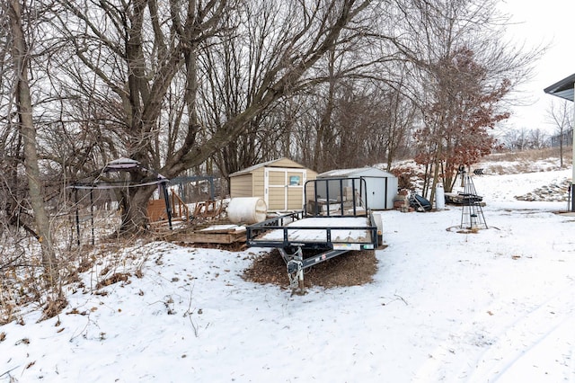 yard layered in snow with a storage unit