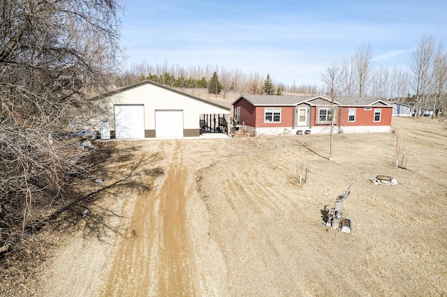 view of yard with a detached garage and an outdoor structure