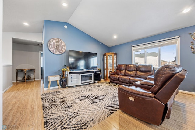 living room featuring wood-type flooring and vaulted ceiling