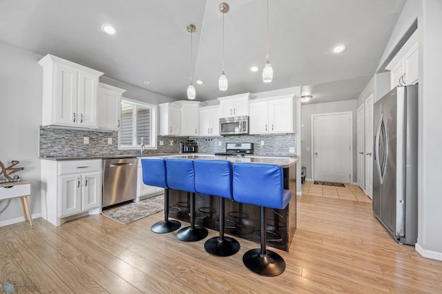 kitchen with white cabinetry, pendant lighting, a center island, and stainless steel appliances